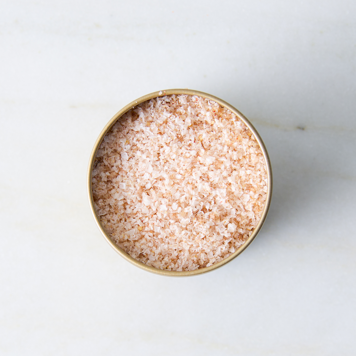 a container of salt on a marble surface