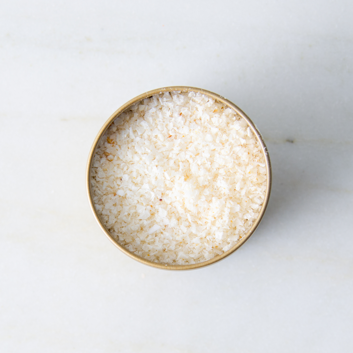 a container of salt on a marble surface
