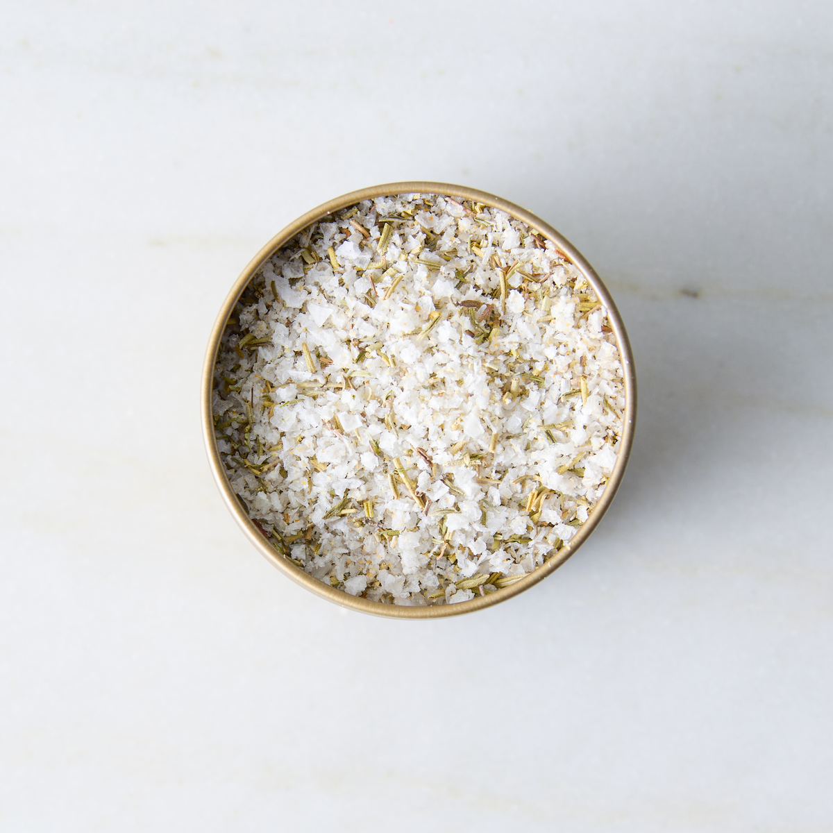 a container of salt on a marble surface