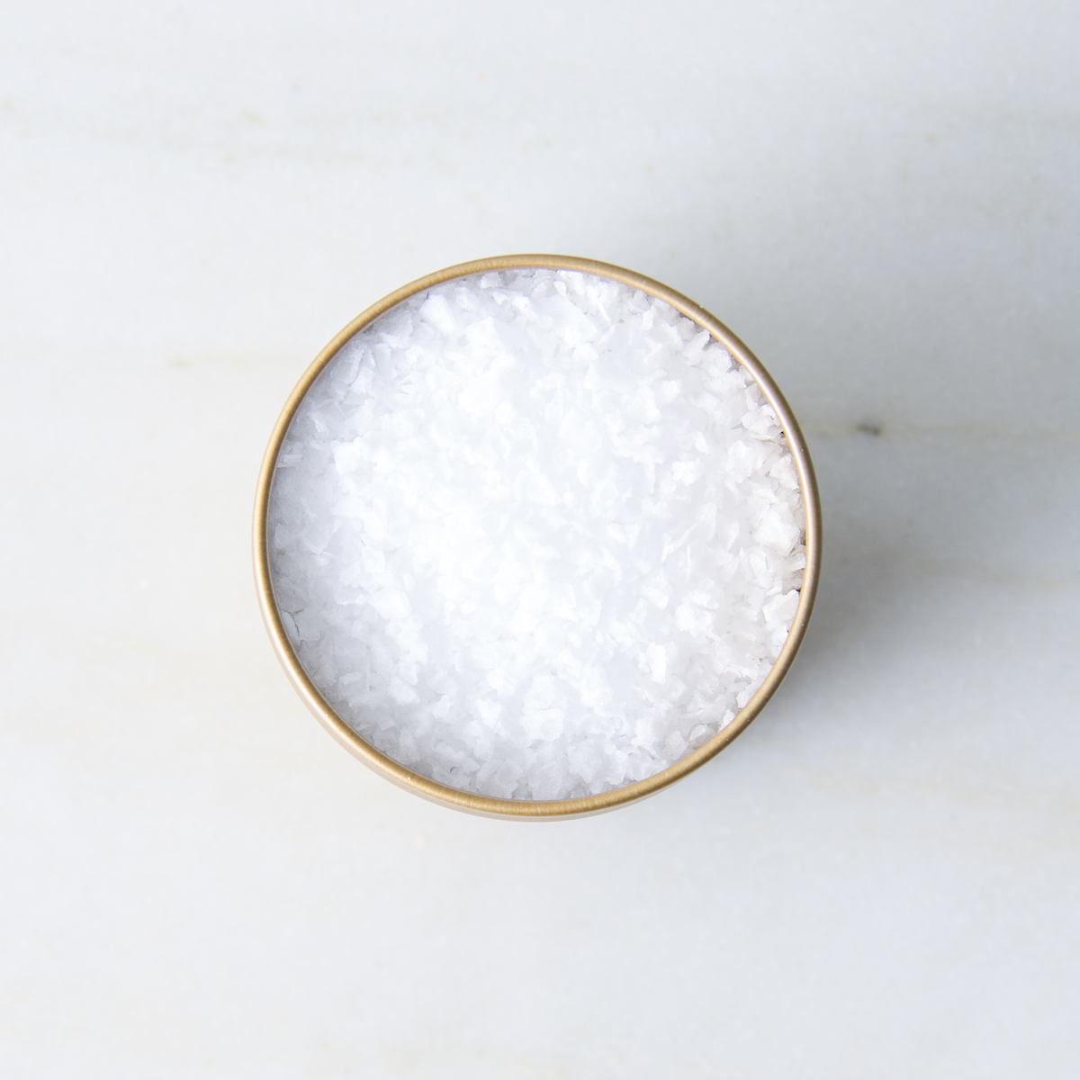 a bowl of salt on a marble surface