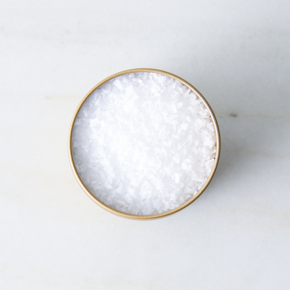 a bowl of salt on a marble surface